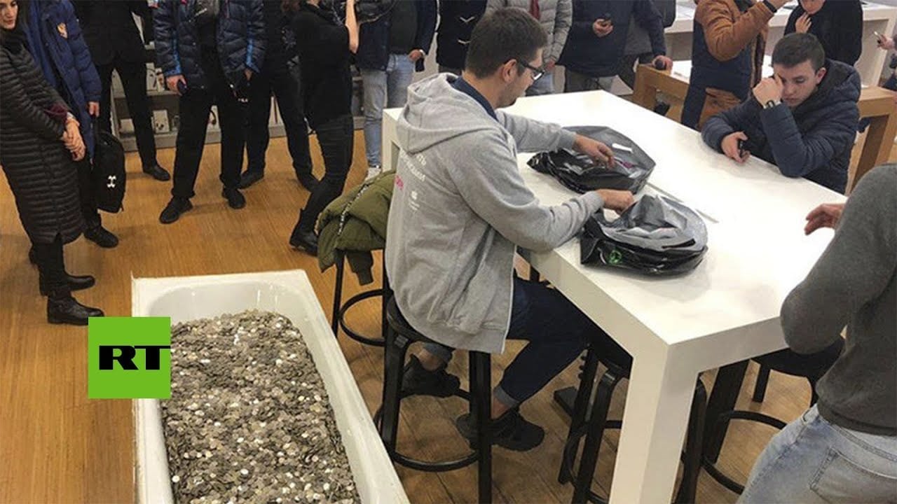 Acude a una tienda a comprarse un móvil con una bañera llena de monedas