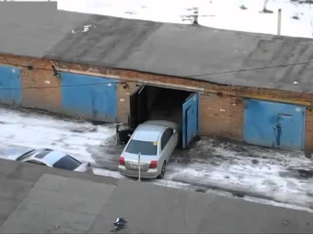 Una mujer intenta entrar por la puerta del garaje.